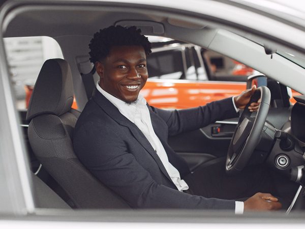 Handsome and elegant black man in a car salon